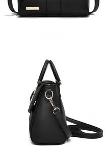 Close-up of black embossed faux leather handbag with golden hardware and top handle