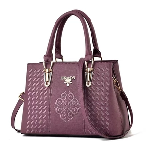 Detailed macro view of purple faux leather texture with elegant embroidery and gold hardware
