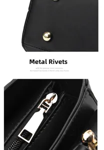 Detail of gold metal studs on the bottom and metal zipper of this black leather handbag