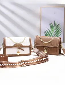 Detail of quilted leather bags with gold chain handles and patterned knit straps