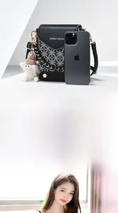 Detail of black crossbody phone bag with chain strap and cute knit cap charm accessory