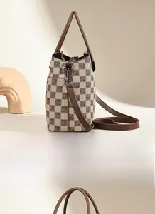Detail view of the side pocket on the beige and brown checkered bucket handbag