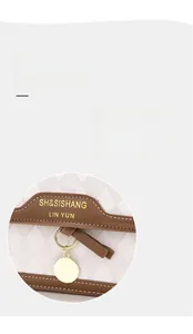 Detail of cream woven texture handbag with brown leather trim and golden logo