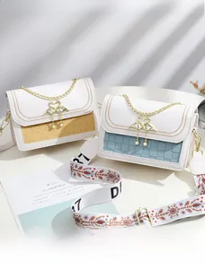 Détail du fermoir cygne élégant et de la texture tressée sur le petit sac carré