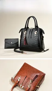 Detail of crocodile pattern leather handbags in black and red with fringe tassels
