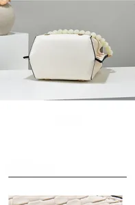 Detail of crossbody bag featuring textured faux leather base and pearl beaded handle