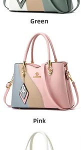 Close-up of color-block leather handbag with golden brand logo and butterfly pendant