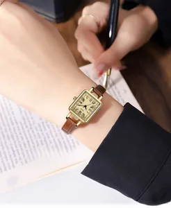 Vintage square watch with gold case, Roman numerals, and brown leather strap on wrist