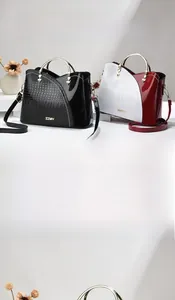 Détail d'un sac à main en cuir à motif crocodile avec poignée dorée et finition polie