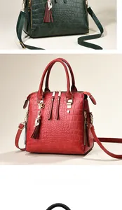 Detail of crocodile pattern tote with metal cat pendant and tassel in green and red