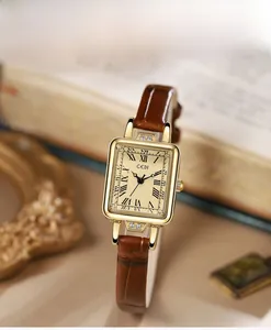 Detail of vintage square gold watch with Roman numerals and brown leather strap