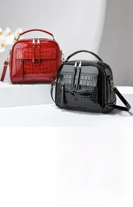Sacs à bandoulière en cuir verni brillant avec motif croco sur des marches blanches