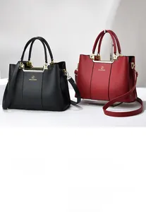 Close-up of litchi grain leather handbags in black and red with golden hardware