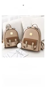 Détail de deux sacs à dos en similicuir beige et marron avec pompons et nœuds décoratifs