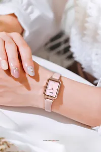Close-up of rose gold square quartz watch with pink leather strap and diamond markers