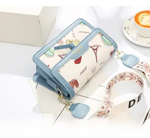 Detail of blue and white crossbody bag with Eiffel Tower prints and jacquard strap