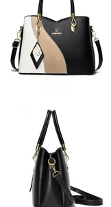 Macro shot of tricolor leather handbag with metallic butterfly and round logo pendant detail