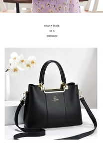 Detail of black lychee grain leather tote bag with gold handle and brand logo
