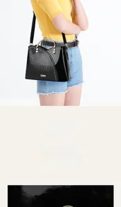 Détail du sac à main noir en cuir motif crocodile avec anneaux métal et fermoir magnétique
