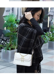 Détails de la sacoche blanche avec boucle de cygne dorée et fine bandoulière chic