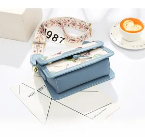Detail of light blue crossbody bag with Eiffel Tower print and adjustable wide textile strap