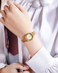 Close-up of Gedi vintage square watch with brown leather strap and gold ring accessory