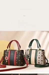 Détail d'un sac vintage monogramme avec rayures contrastées et pendentif smiley en métal