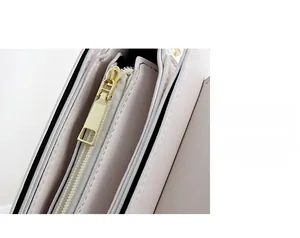 Close-up of high-quality gold metal zipper details on a minimalist fashion handbag