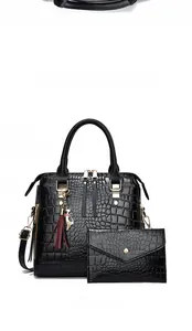 Front view of black crocodile pattern tote bag set with metal tassel and gold hardware