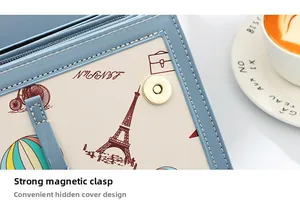 Detail of light blue crossbody bag featuring a magnetic snap and vintage print lining