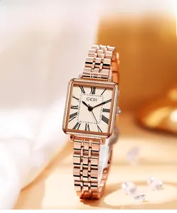 Close-up of elegant rose gold square watch with Roman numerals on white silk fabric