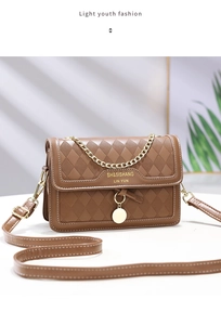 Detail of brown quilted chain bag with white stitching and gold hardware accents