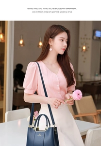 Fashionable dark blue handbag with gold hardware shown in a cozy cafe setting