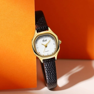 Detail of Gedi quartz watch with gold octagonal case and black faux-snake skin strap