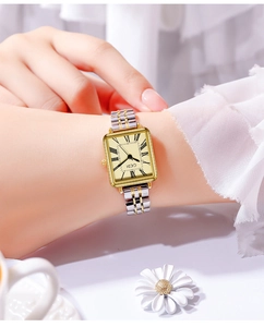 Close-up of golden square vintage quartz watch with Roman numerals on a female wrist