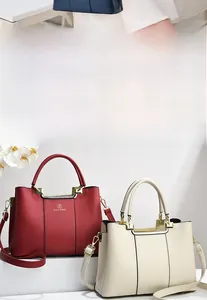 Detail of elegant leather handbags featuring gold brand logo and stylish lychee texture