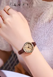 Dettaglio di un orologio al quarzo dorato vintage con cinturino in pelle marrone bamboo