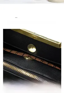 Detail of gold magnetic clasp and striped lining inside black pebble leather handbag