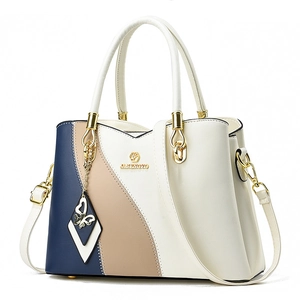 Three-color contrast tote bag in navy, khaki and cream with gold hardware and charm