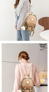 Vue détaillée du petit sac à dos beige en similicuir avec boucle en métal et pompon blanc