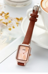 Detail of square rose gold watch with brown leather strap and diamond dial markers