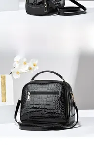 Vue détaillée du sac bandoulière noir motif crocodile avec ferrures dorées et poignée
