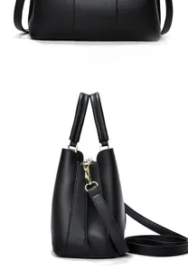 Detail of black lychee-textured leather tote with high-gloss gold metal zippers