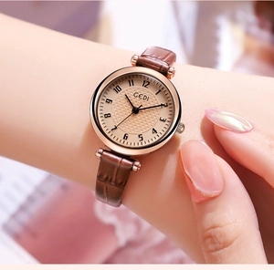 Primo piano di un orologio da donna vintage con cinturino in pelle marrone e quadrante beige