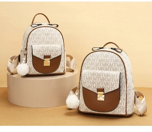 Detail of mini monogram backpack with plush pendant and faux leather trim on display stand