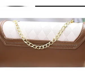Detailed close-up of brown and cream quilted shoulder bag with gold chain and white stitching