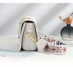 Vue détaillée du sac matelassé blanc avec soufflets en accordéon et bandoulière brodée