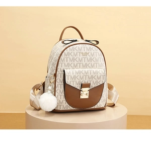 Detail view of monogram backpack with gold metallic lock and fluffy pearl charm