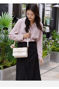 Chic beige crossbody bag featuring a delicate gold chain and elegant silk scarf accent