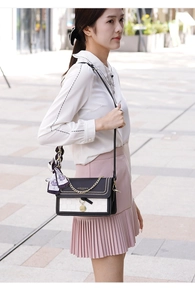 Detail of color-block flap bag with gold rivets, chain, and floral silk scarf charm